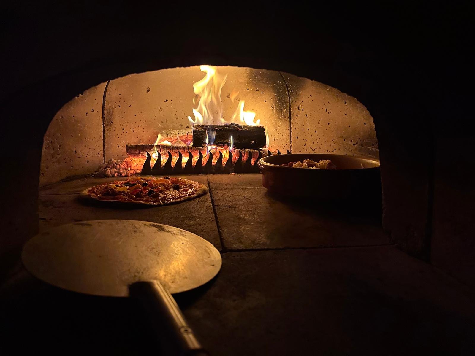 Another pizza going into the wood-fired oven