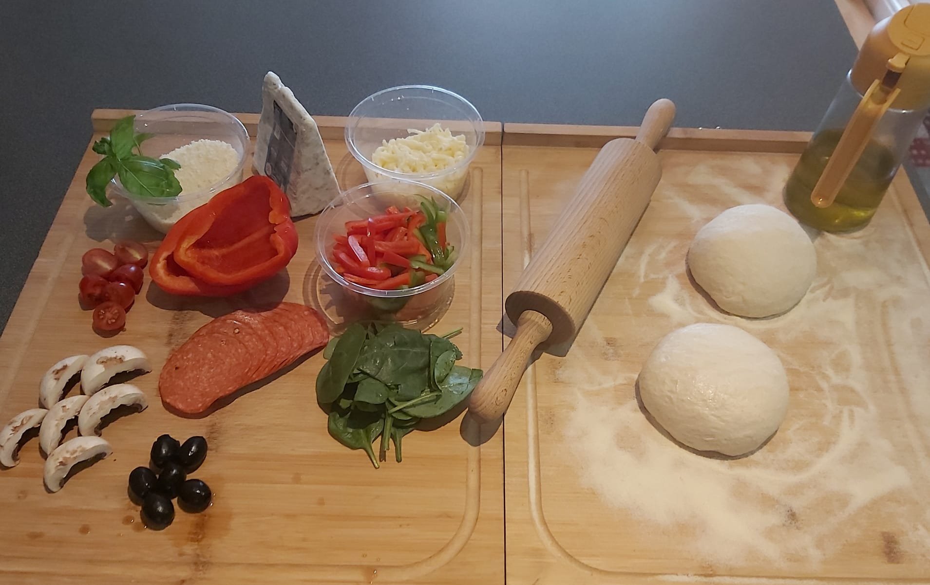 Fresh pizza dough balls on wooden board with pizza ingredients